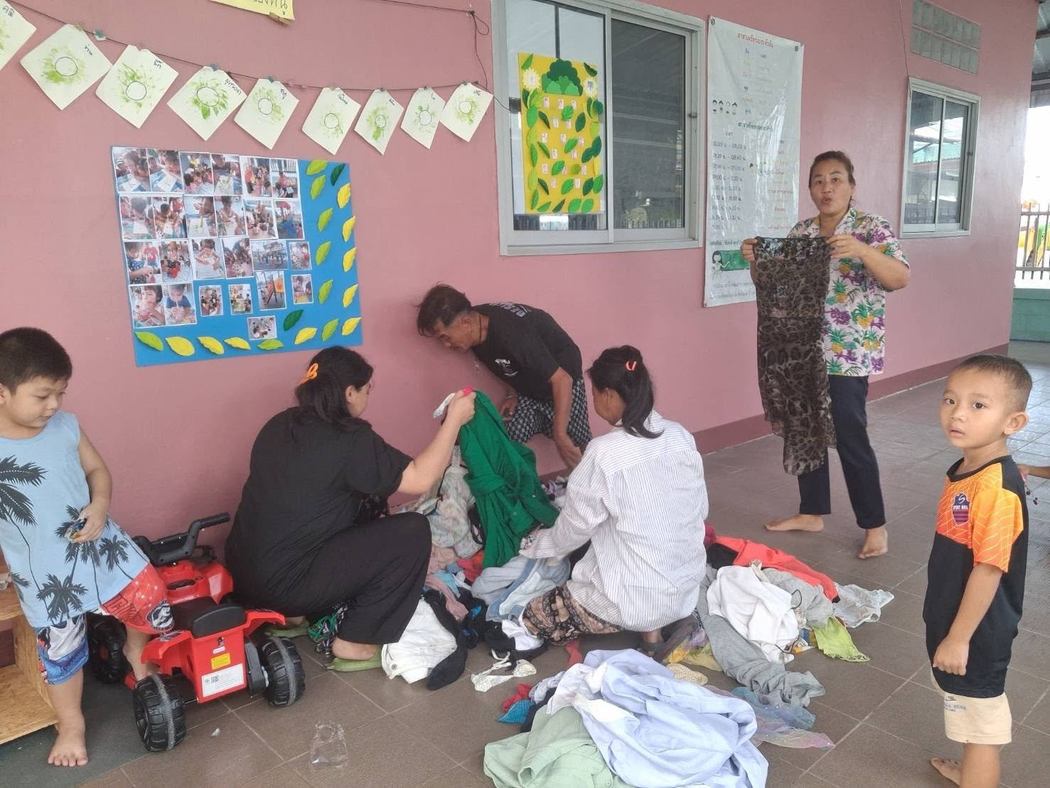 Community members sorting through donated clothes and practical goods in the slum neighborhood.