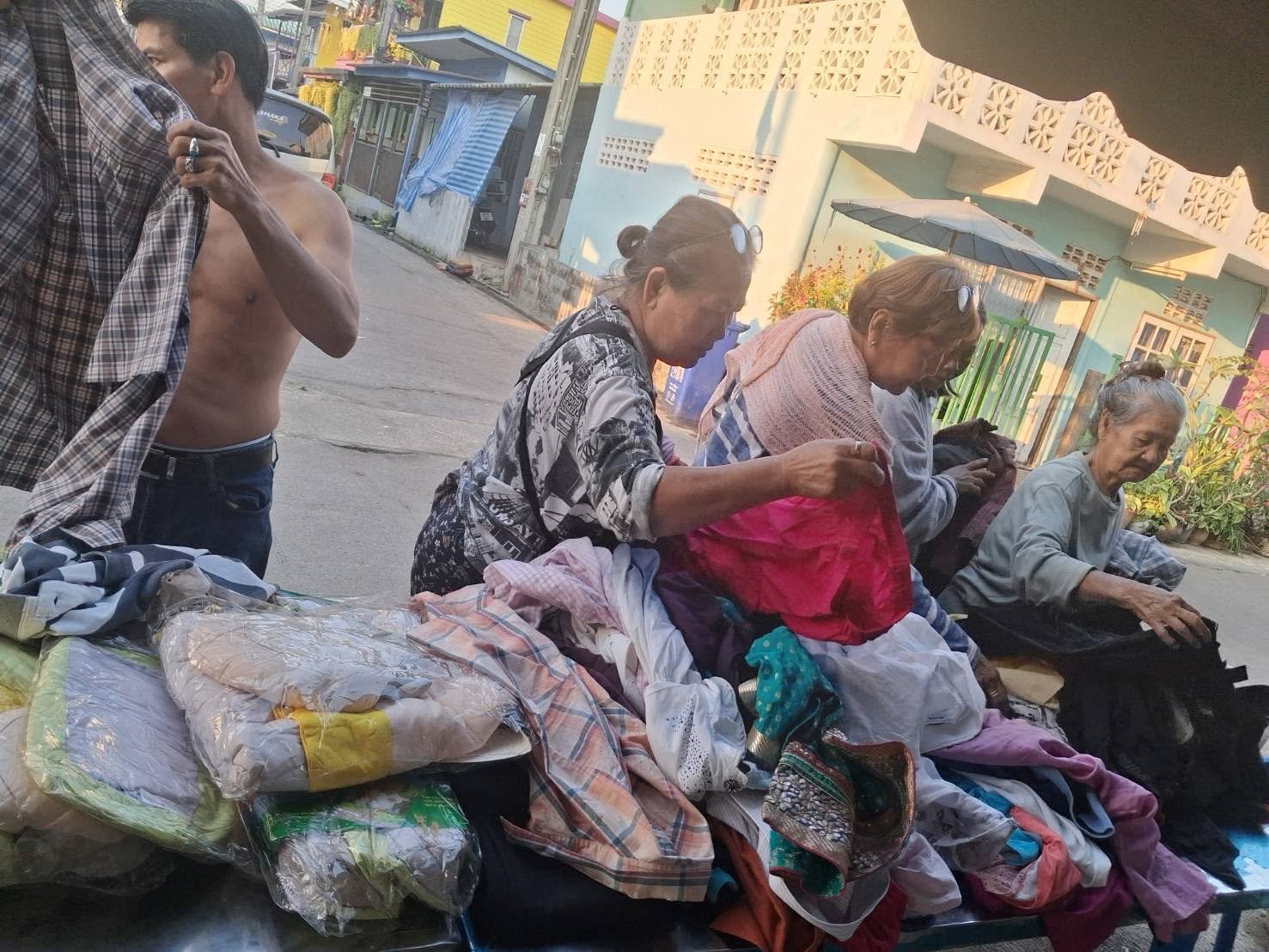 Families and residents selecting donated goods from a community distribution table.