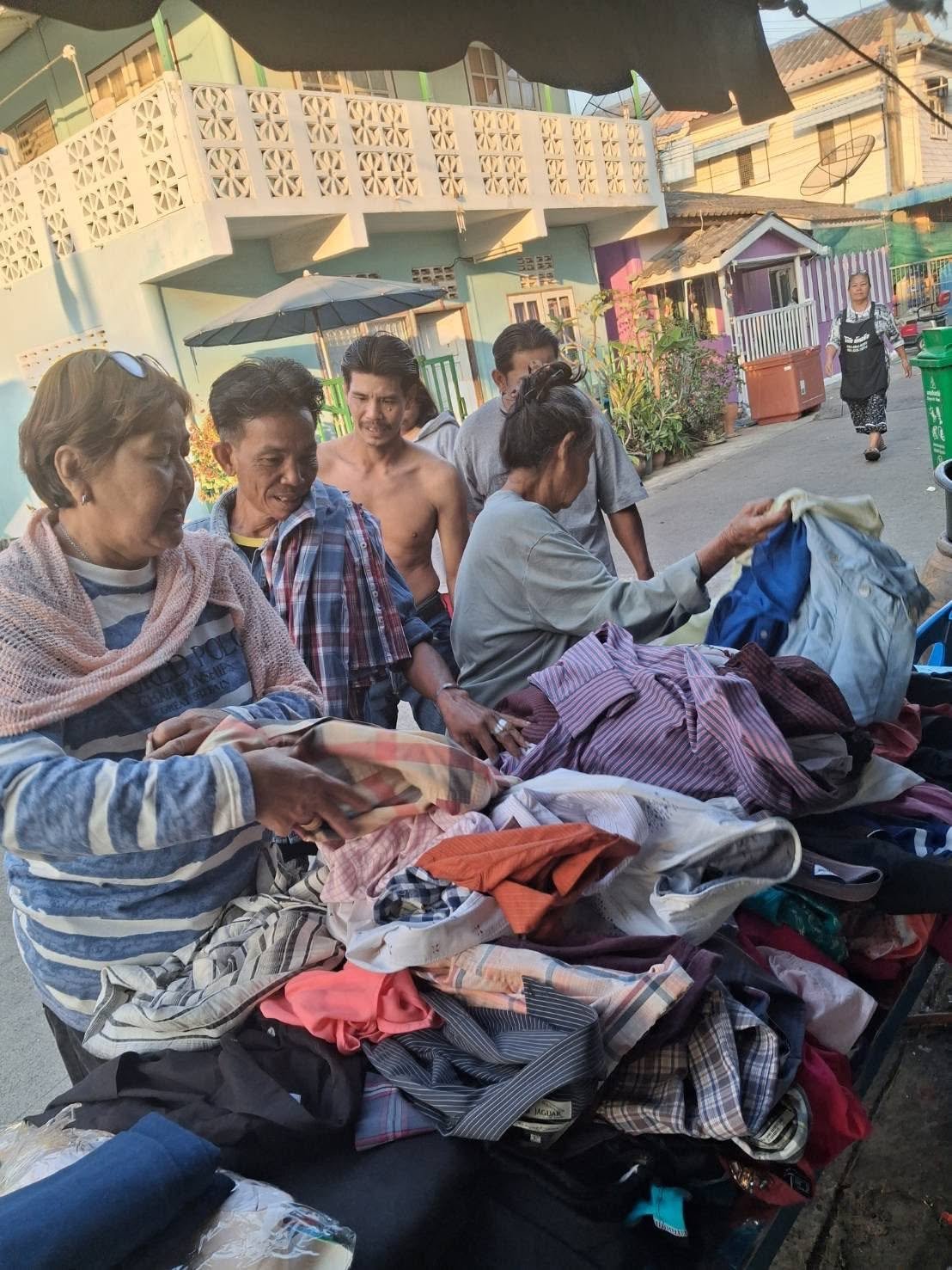 Residents gathered around donated clothing and supplies in the slum community.